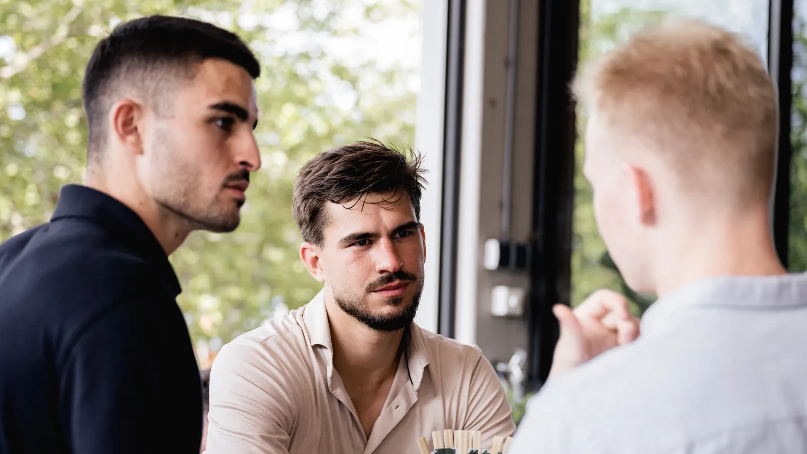 Tim Tielkemeijer talking with two business owners at a table